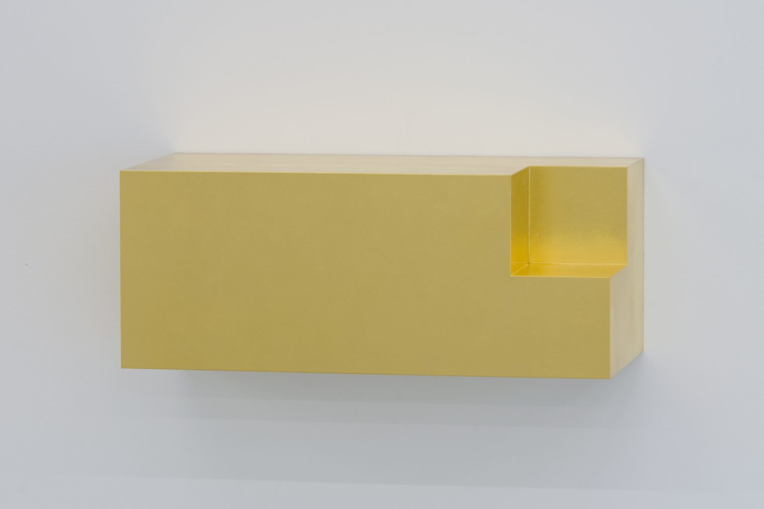 壁面に設置された長方形の黄色い立体作品