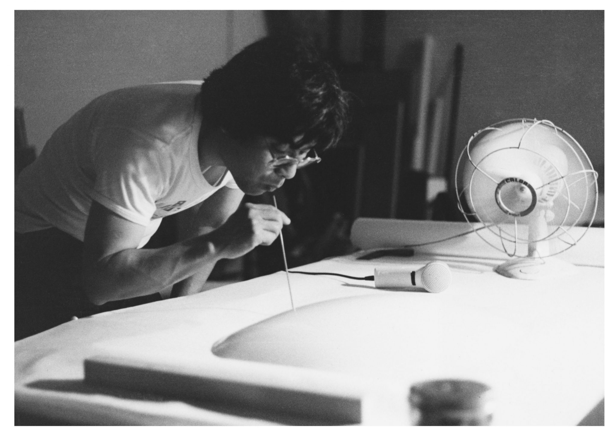 black and white photograph of artist Takesada Matsutani exhaling air into vinyl adhesive in 1981