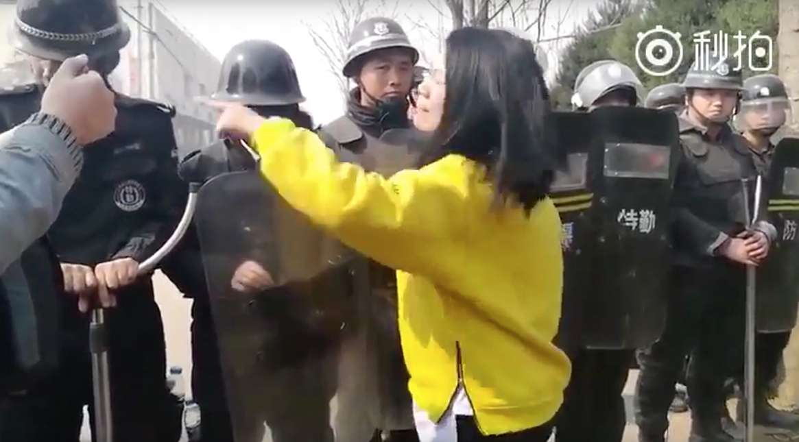 protestor confronts Chinese security officials in Songzhuang