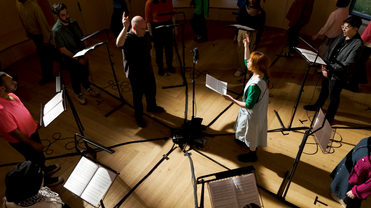 Mat Dryhurst and Holly Herndon conduct a recording session with London Contemporary Voices in London for The Call, 2024. Courtesy Foreign Body Productions, London