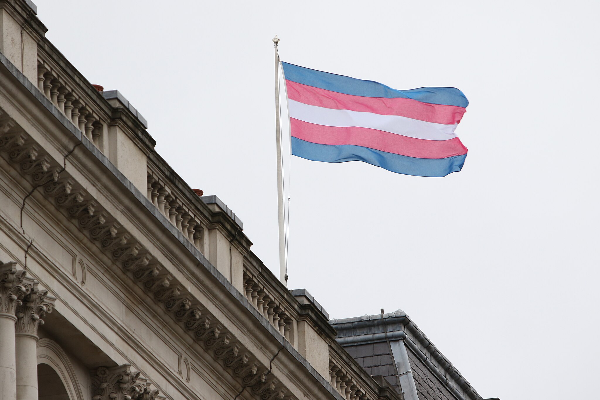 The Transgender Pride Flag flies on the Foreign Office building in London on Transgender Day of Remembrance, 2017 Photo: Foreign and Commonwealth Office, CC BY 2.0, via Wikimedia Commons