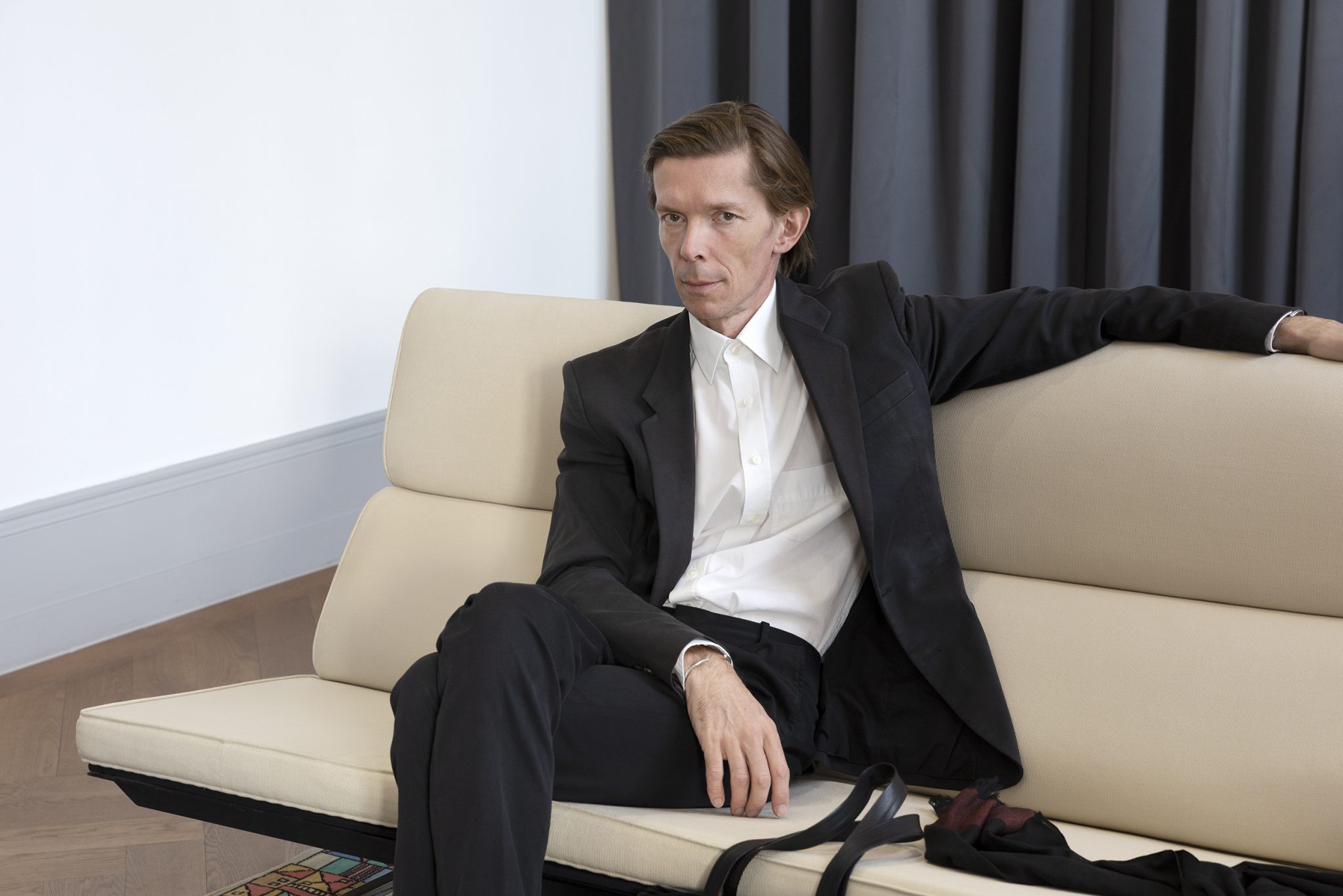 Adam Szymczyk sitting on a couch facing the viewer