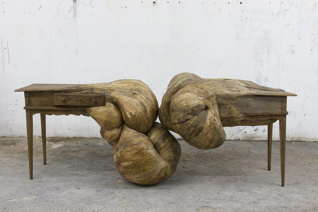 A sculpture showing two desks with bulbous forms