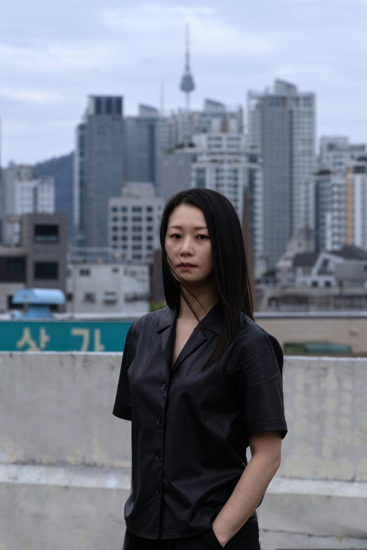 YoungEun Kim facing the viewer, standing in front of a cityscape