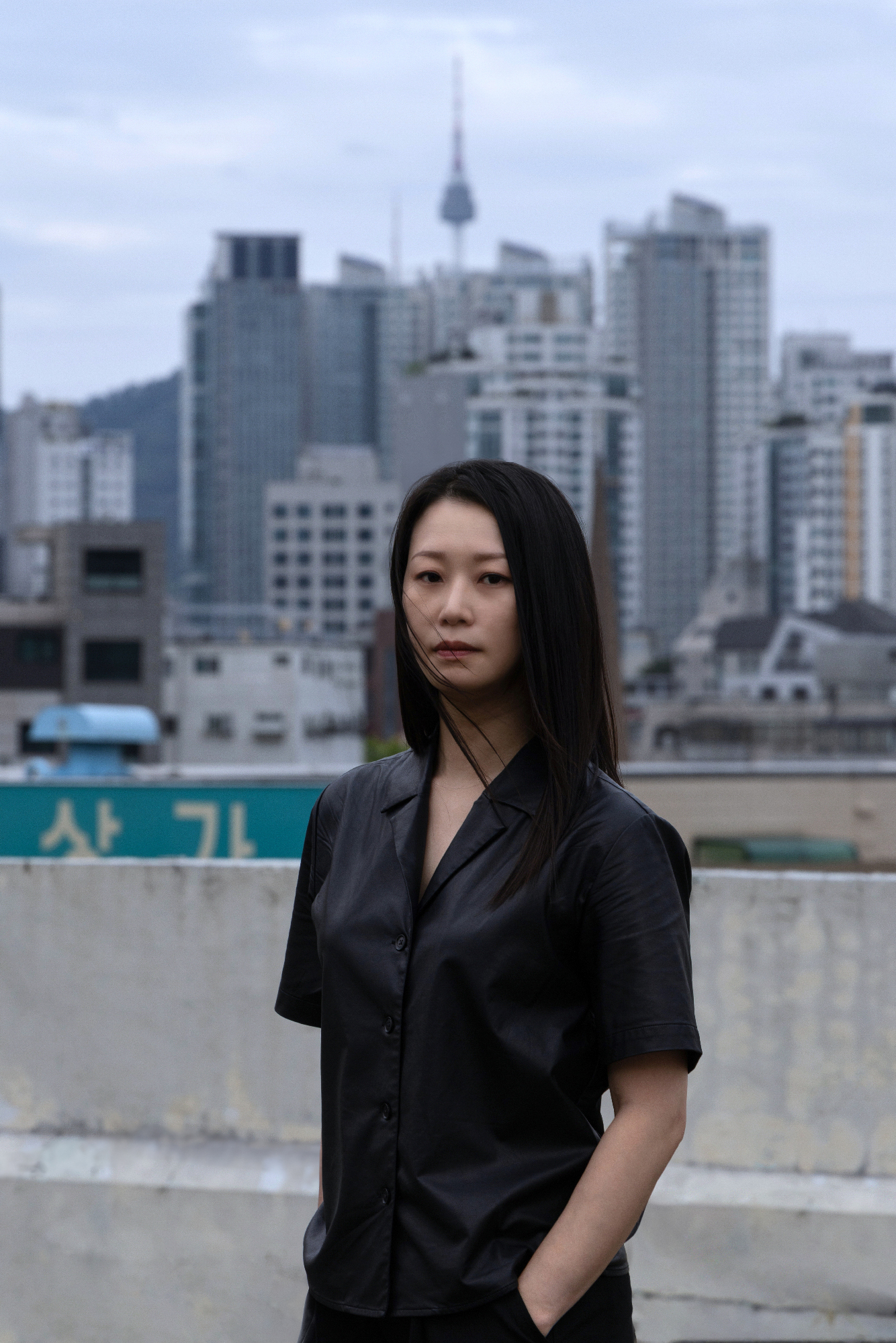 YoungEun Kim facing the viewer, standing in front of a cityscape