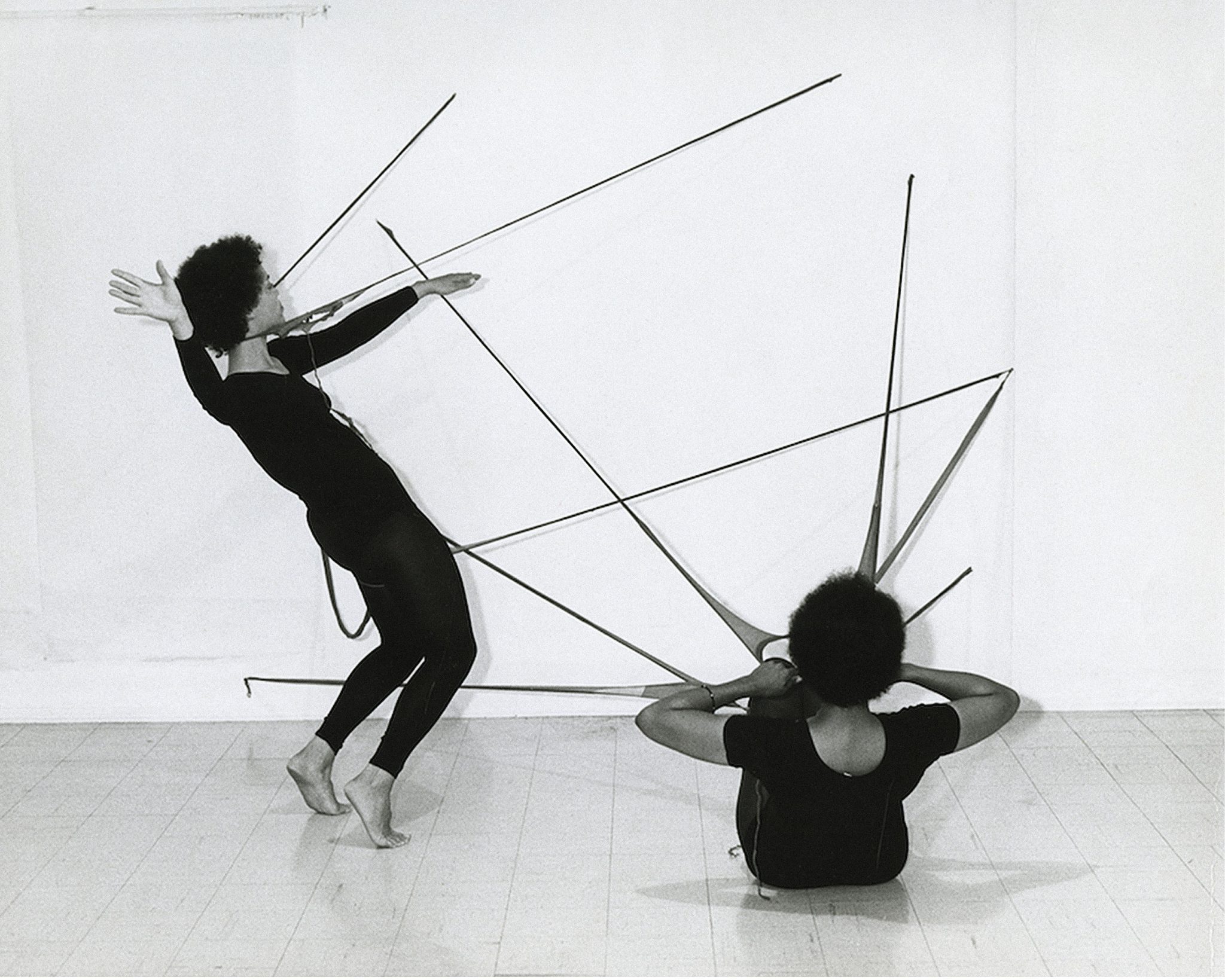 Two people next to a wall with long spikes coming out of them