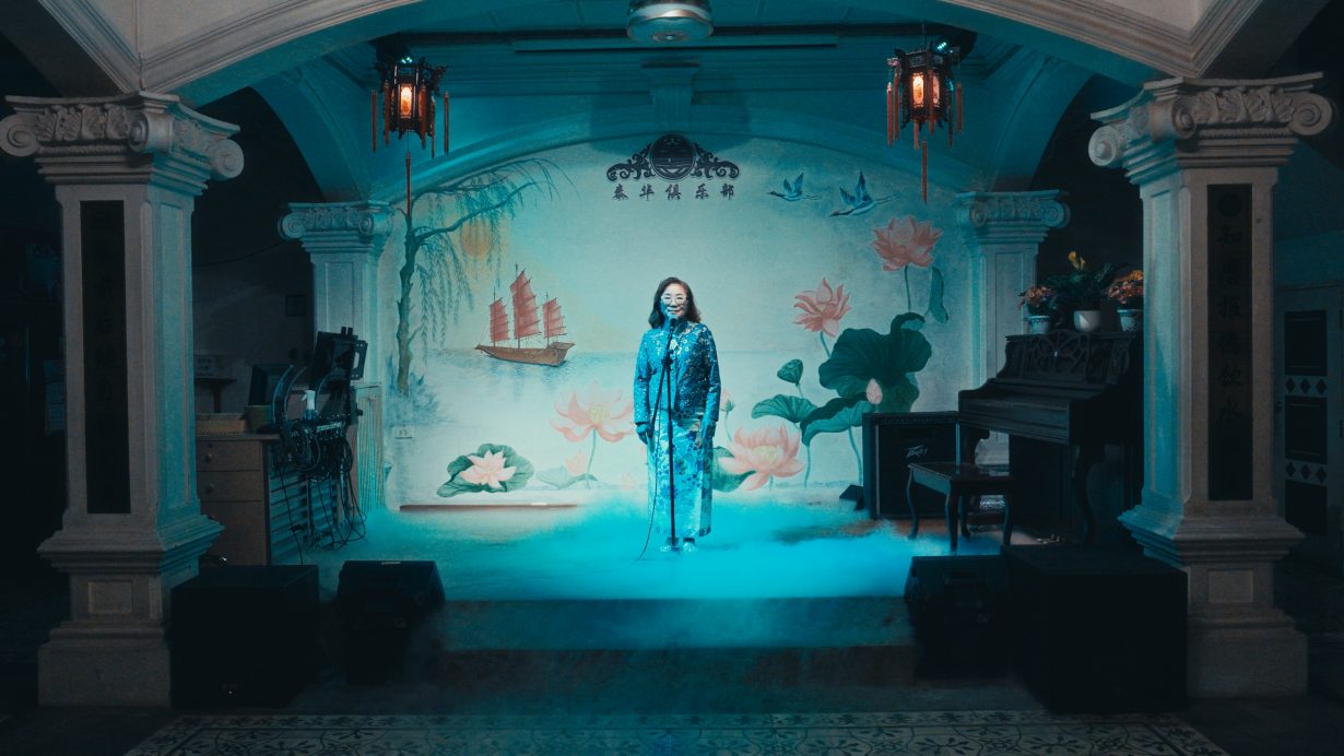a film stil of a woman standing on a stage 