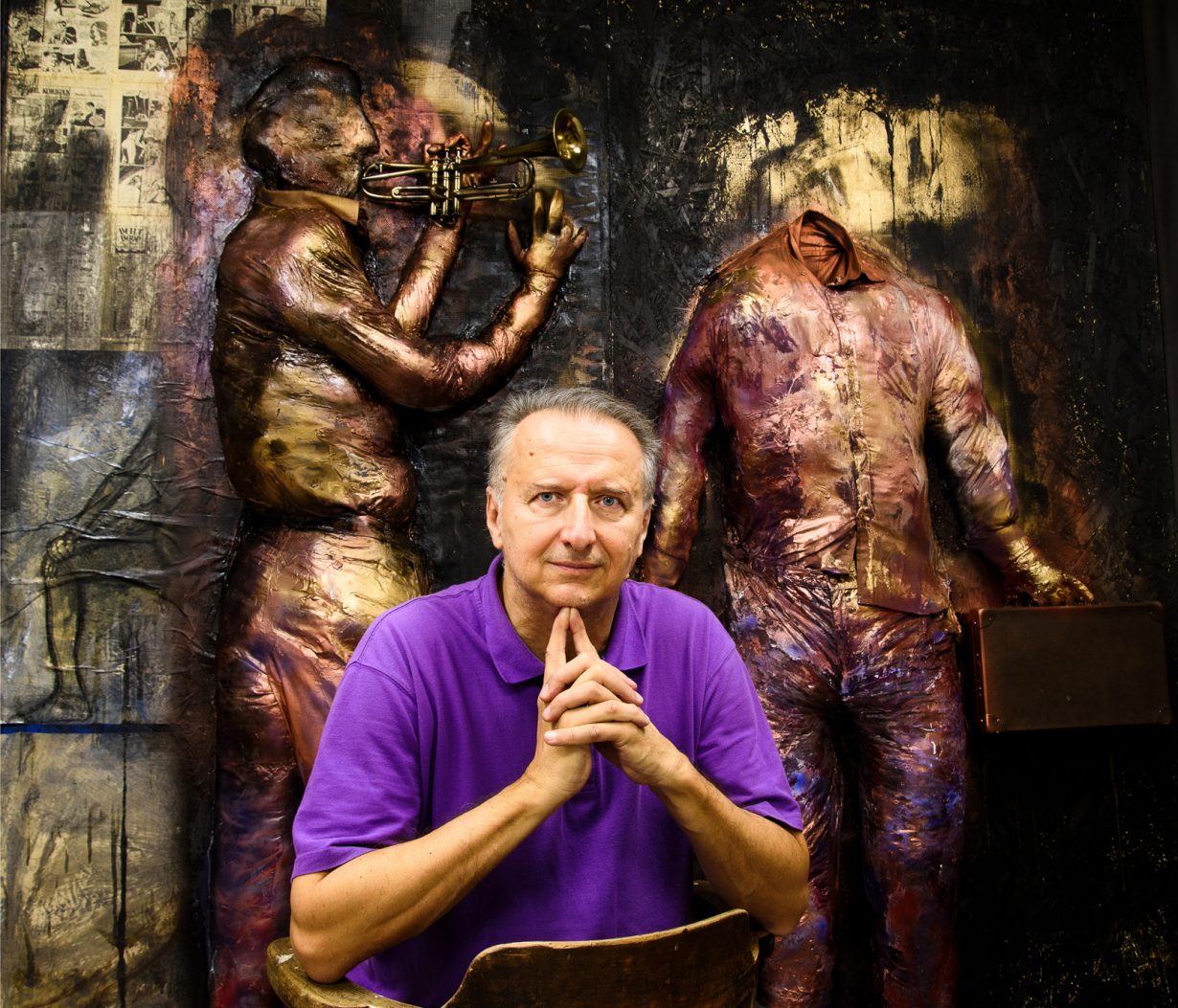 Pedja Djaković sitting in front of a bas-relief of musicians