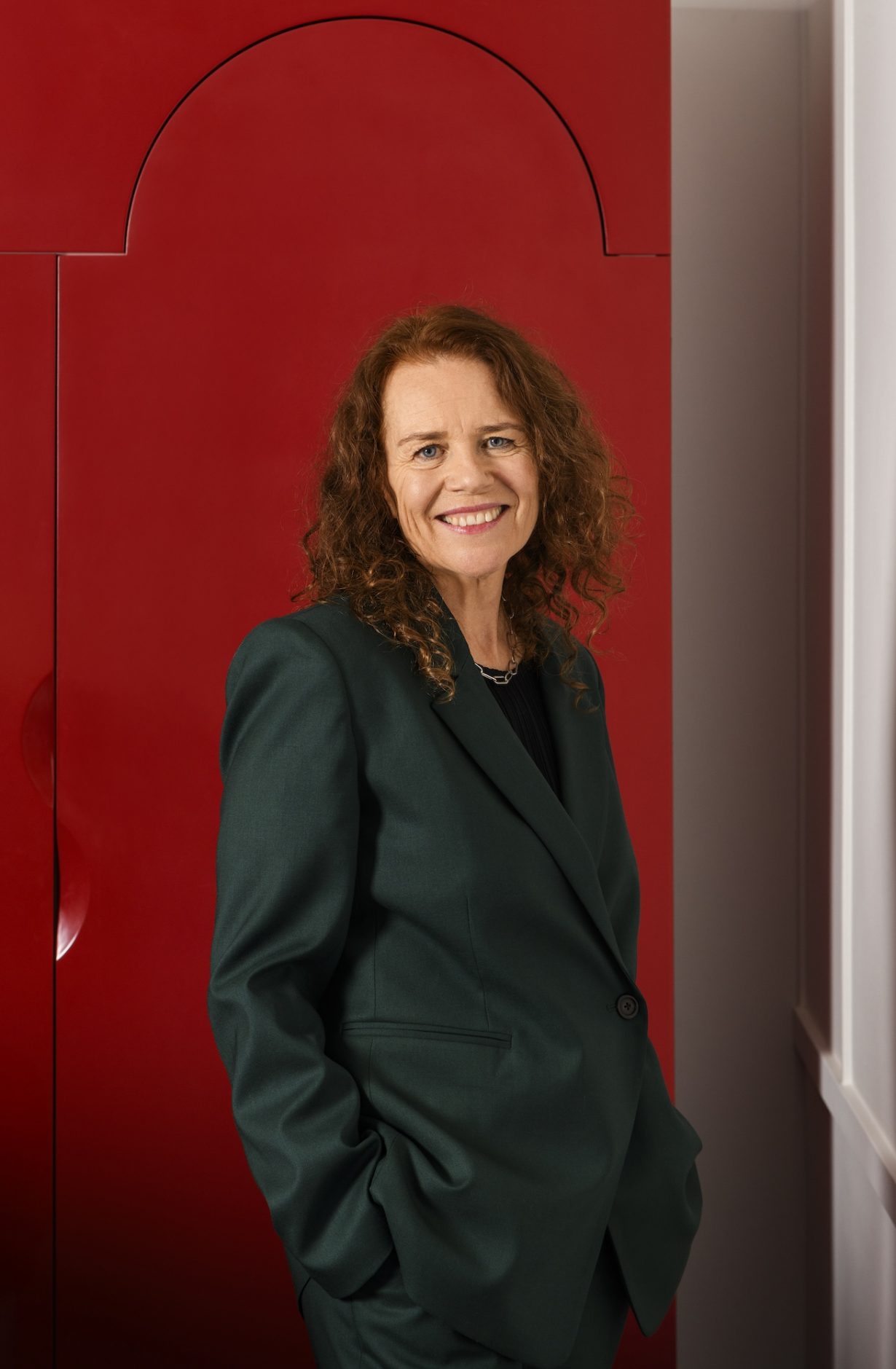 Sally Tallant against a neutral red background