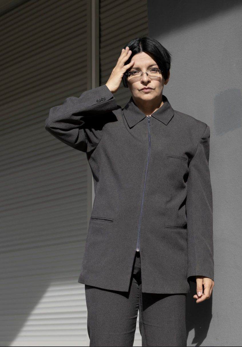 Photo of Henrike Naumann standing. She is wearing a gray suit