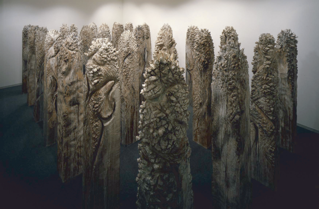 Photo of Shigeo Toya's Wood, 1987, a forest of carved wood totems in a gallery