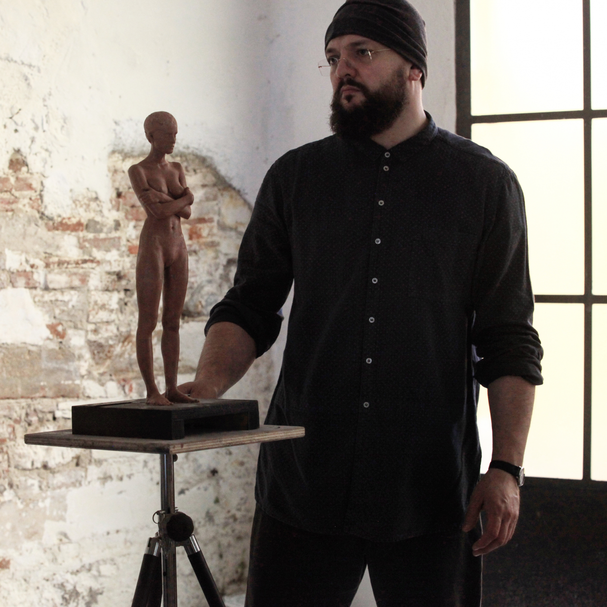 Alexey Morosov standing with a small sculptural figure