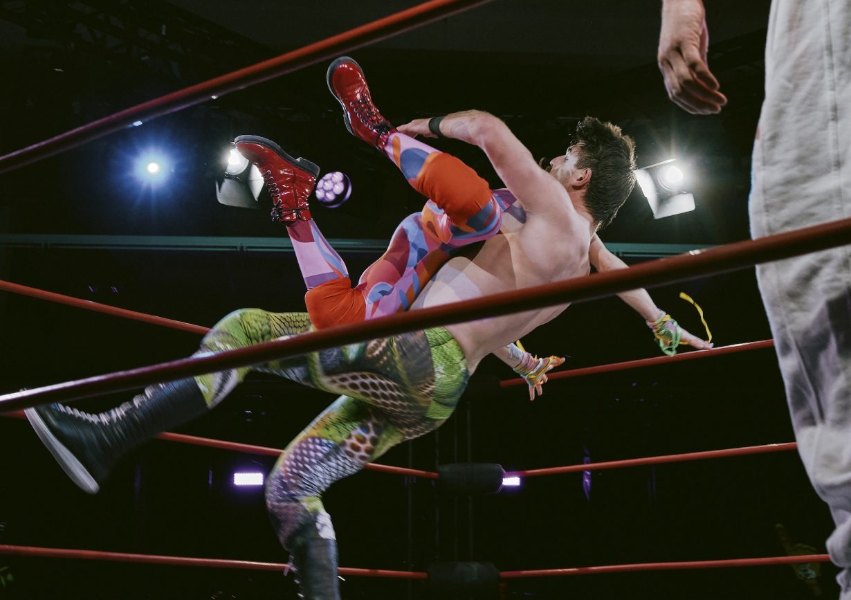 Two wrestlers mid-jump in a ring