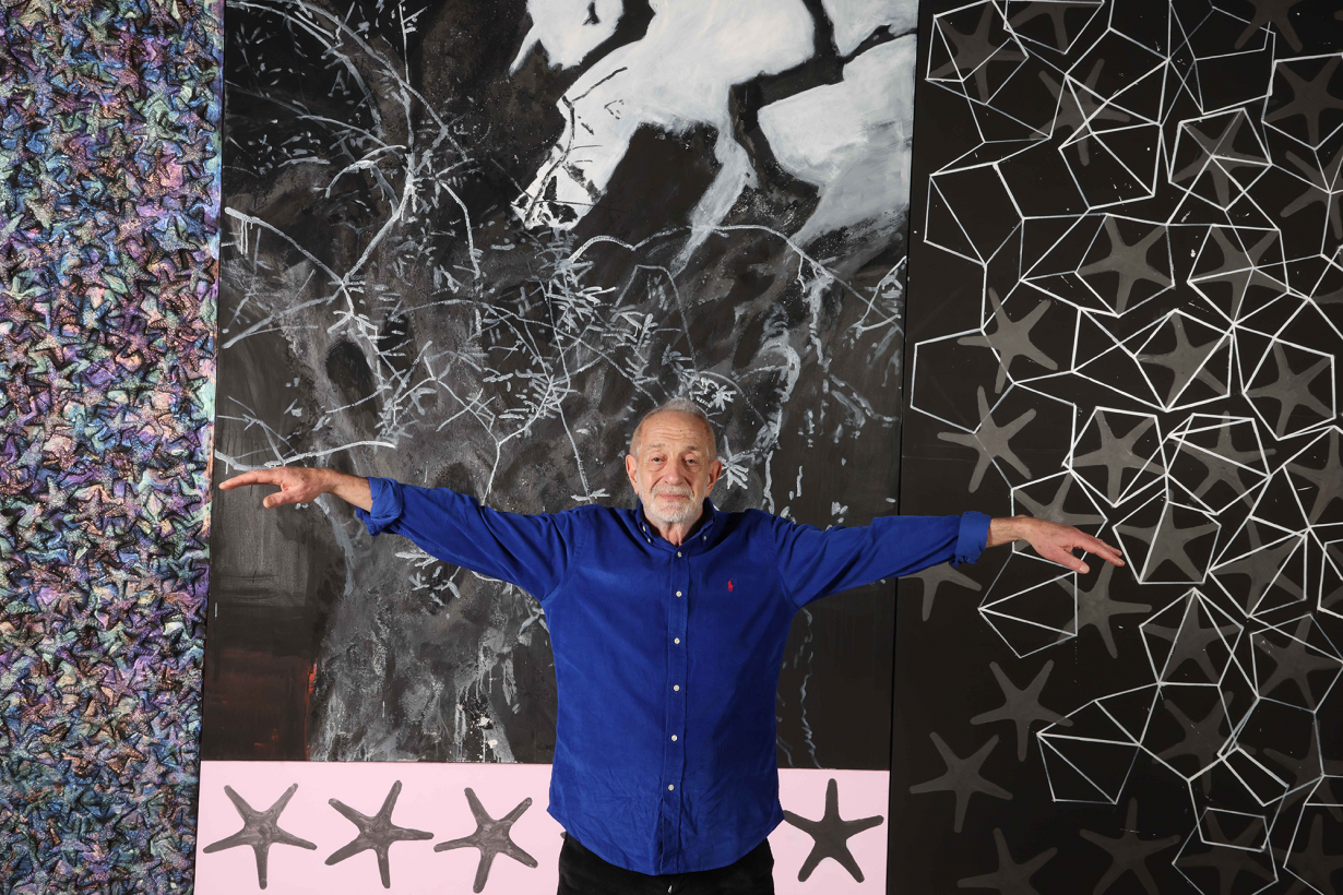 Nabil Nahas standing with his arms spread out in front of his work