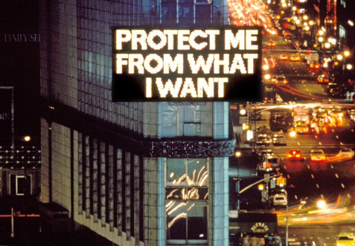 An LED advertissing board in New York's Time Square displaying the slogan 'Protect Me From What I Want'